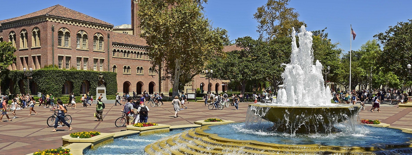 photo of campus with students walking and fountain