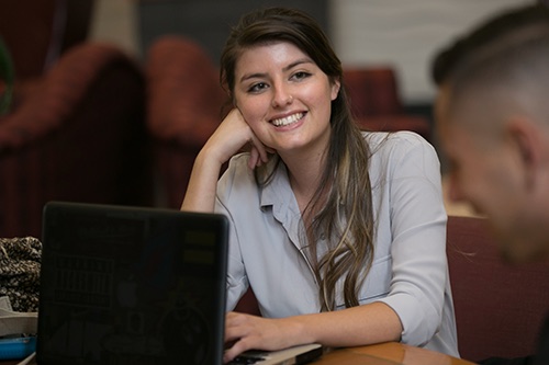 Photo of student or tutor smiling at a conference table